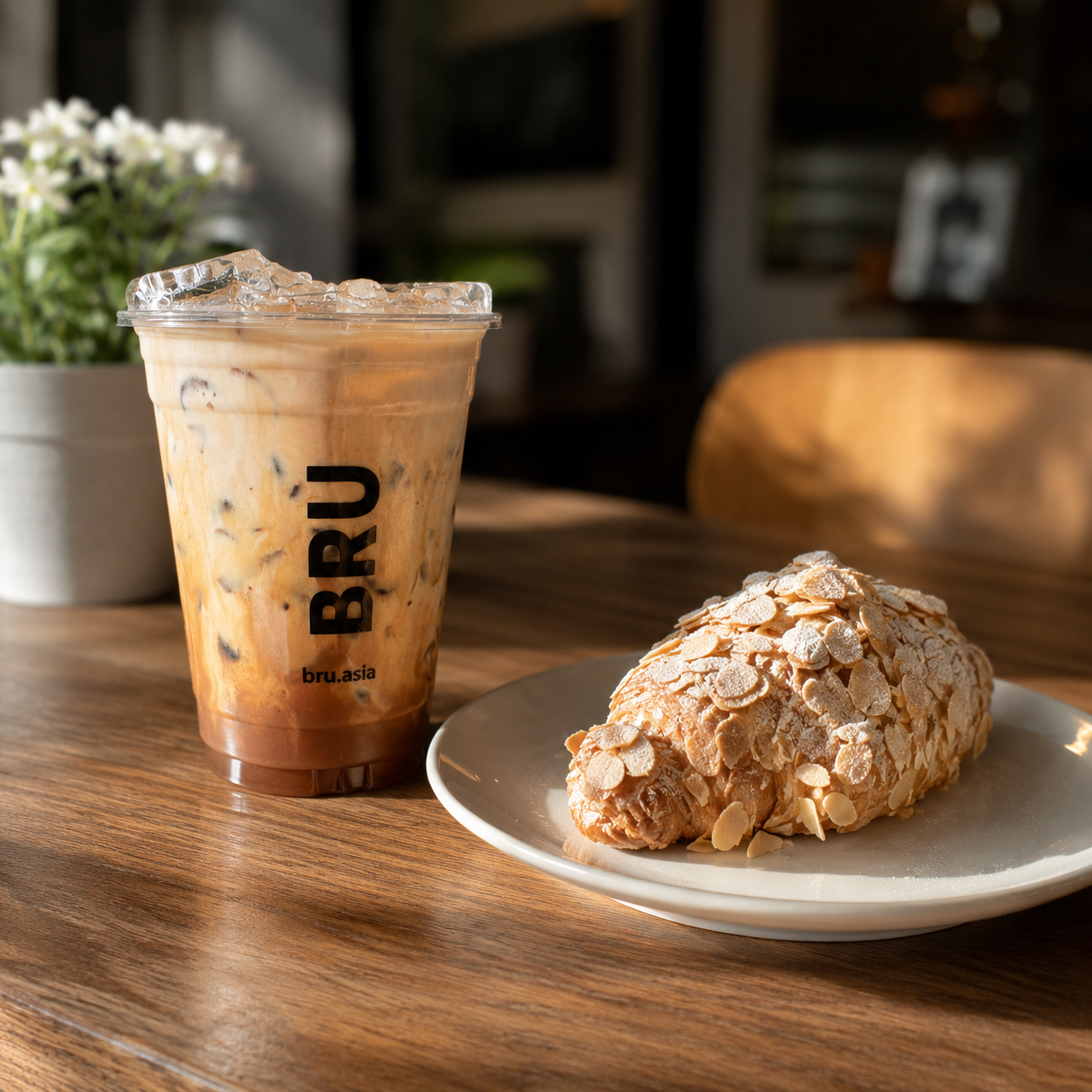 Nutella iced latte and almond croissant on a wooden café table